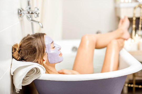 woman relaxing in bath with face mask on 